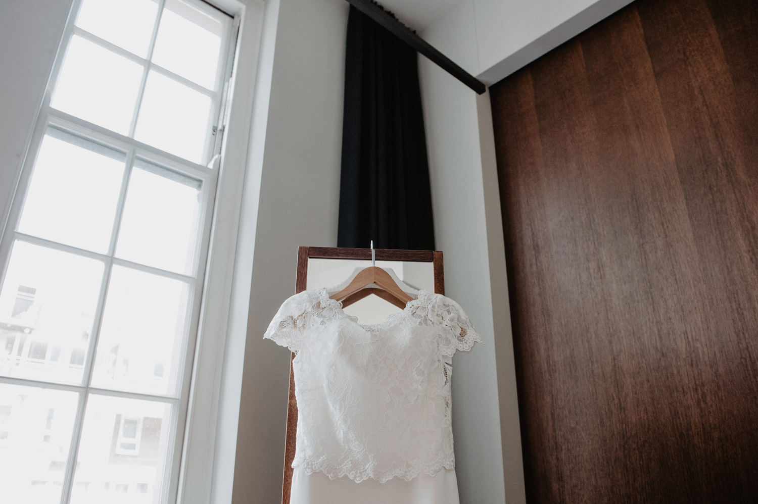 london town hall hotel wedding dress hanging on midcentury modern mirror