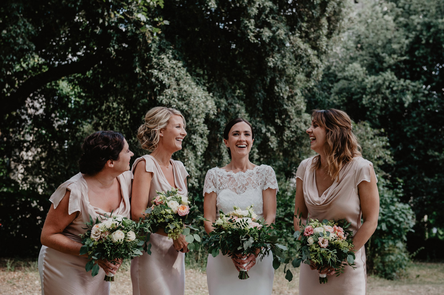 bride with bridesmaids in pastel dresses having wedding photos clissold park 