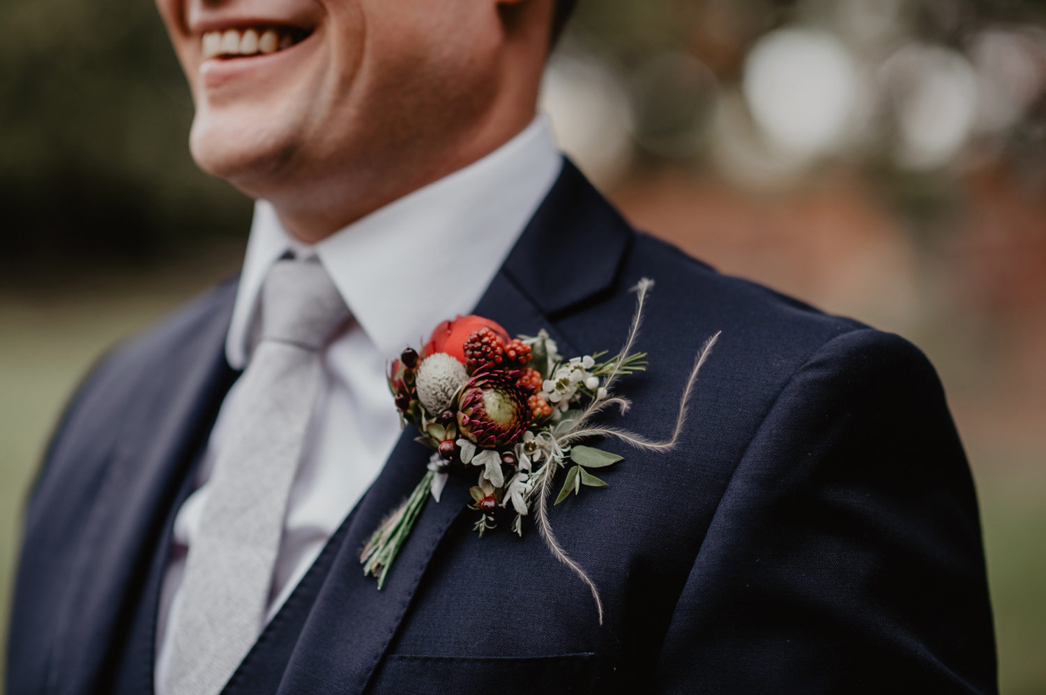 groom maroon red flowers buttonhole