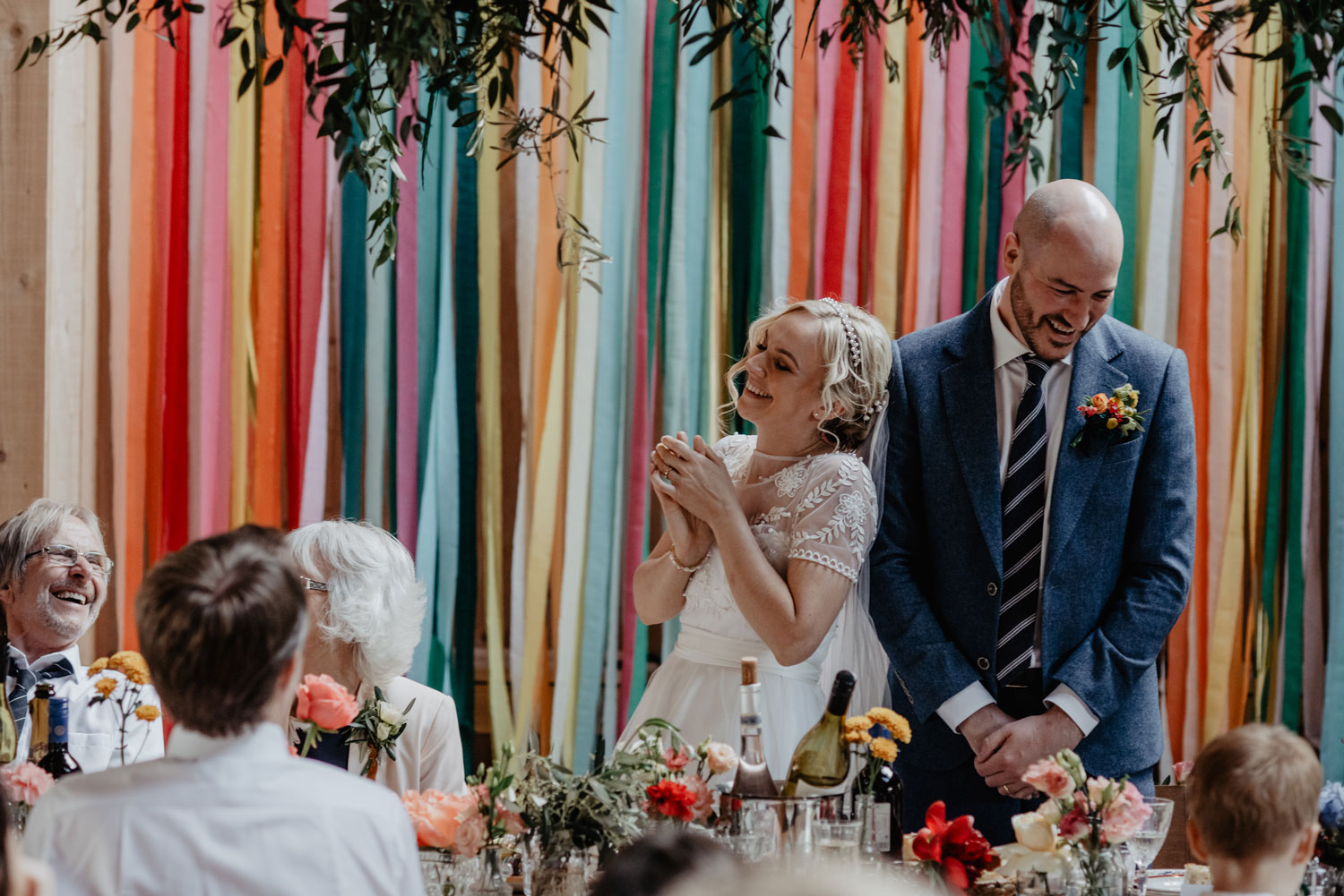 abbey hall eye suffolk wedding smiling bride walking down the aisle carrying a pink peony bouquet by anne schwarz photography