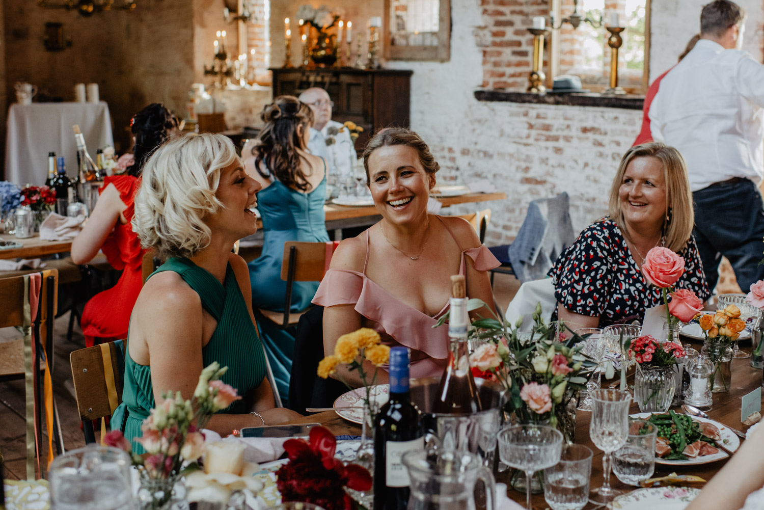 abbey hall eye suffolk wedding smiling bride walking down the aisle carrying a pink peony bouquet by anne schwarz photography