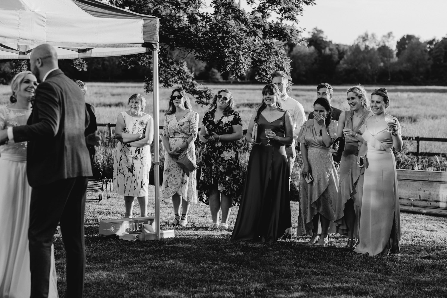 abbey hall eye suffolk wedding smiling bride walking down the aisle carrying a pink peony bouquet by anne schwarz photography