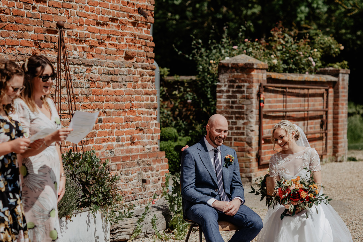 abbey hall eye suffolk wedding smiling bride walking down the aisle carrying a pink peony bouquet by anne schwarz photography