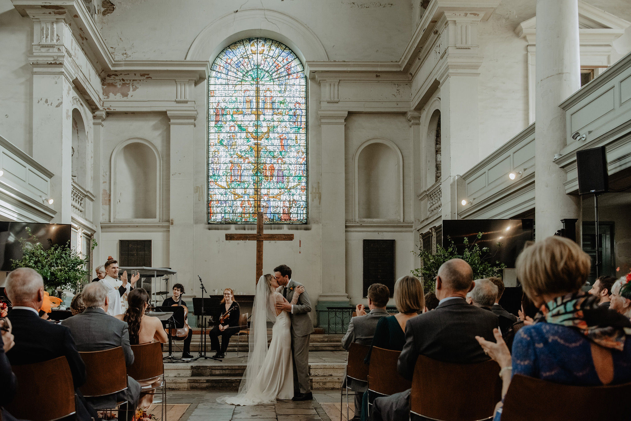 romantic first kiss at the altar in st leonards church shoreditch with photography by anne schwarz