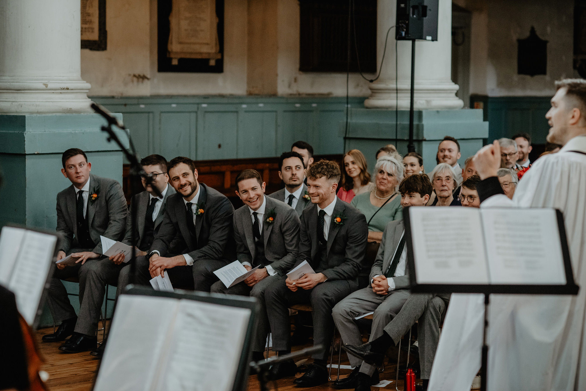 groomsmen laughing during wedding service at shoreditch church