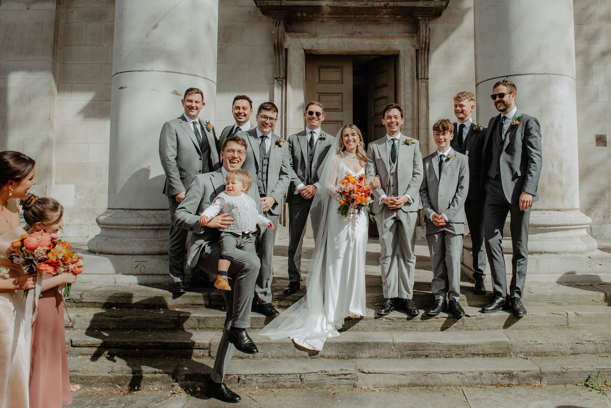 fun ushers group photo on church steps in shoreditch st leonards wedding