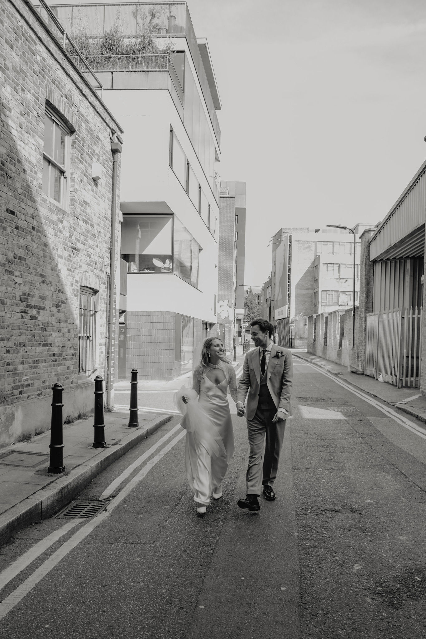 editorial style wedding black and white editorial style picture of bride and groom walking at shoreditch studios 