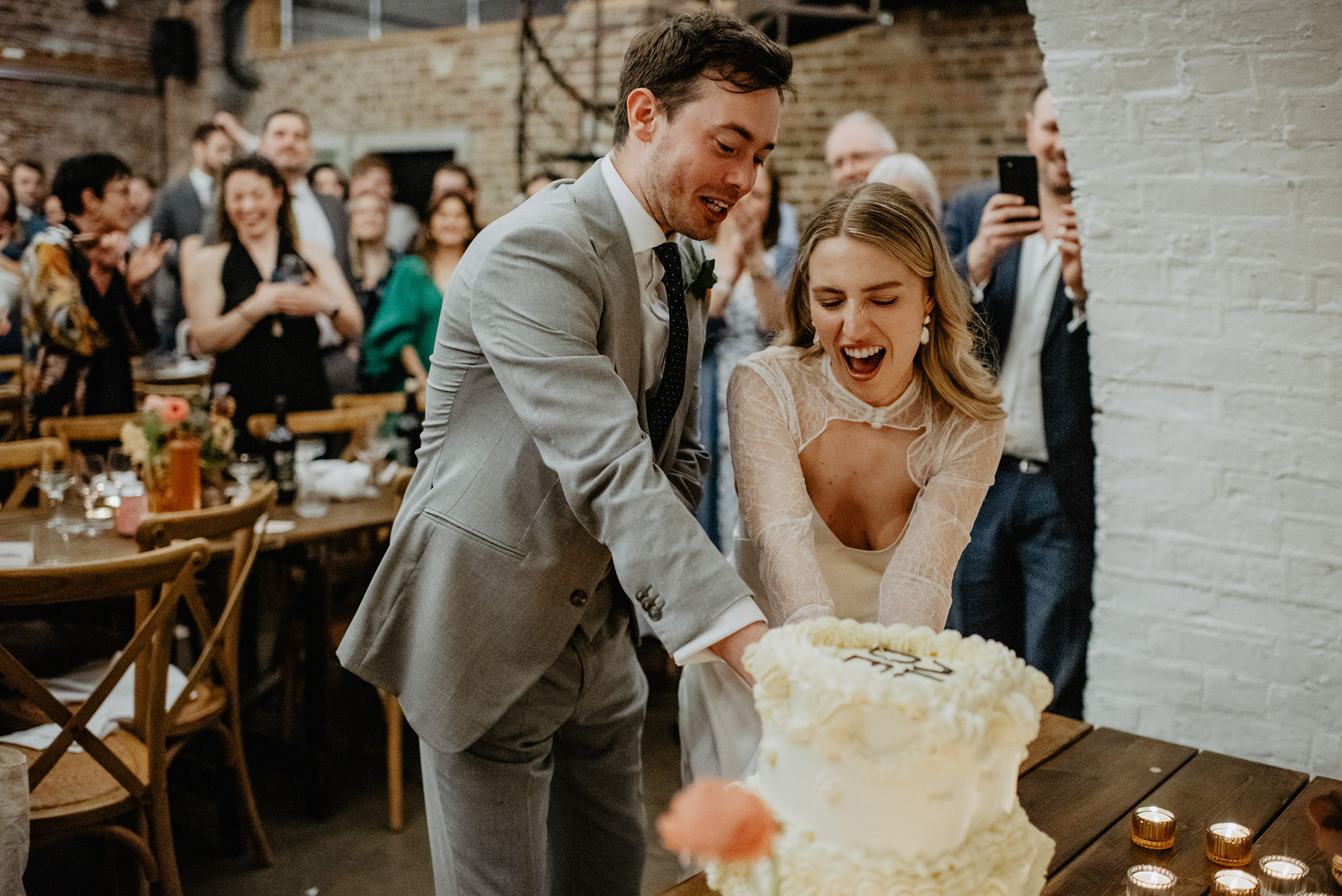 cutting of a buttercream wedding cake at shoreditch studios in london